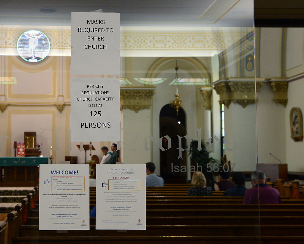 Signs on the windows instruct parishioners to wear masks